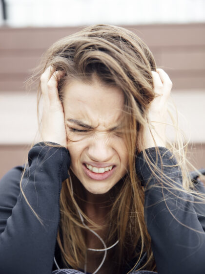 Portrait of angry sad young woman sitting outdoor