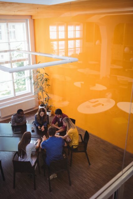 Business executives interacting with each other while having coffee in office